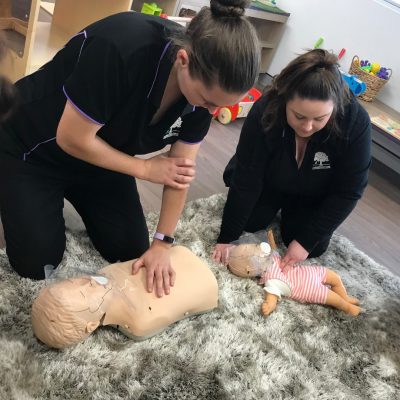 2 childcare educators practicing cpr on infant and child manikins. Doing their HLTAID012 Provide First Aid in an Education and Care Setting Course at their Workplace