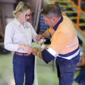 2 staff practicing bandaging in a HLTAID011 Provide First Aid course at their workplace as part of workplace safety