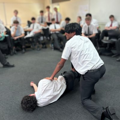 teenagers practicing the recovery position in a cpr class, youth CPR courses Brisbane, student wellbeing programs
