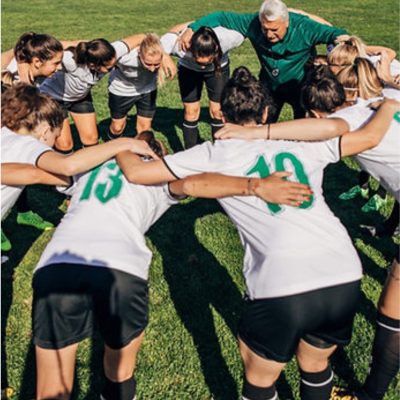 Soccer team huddling together on the field, prepare participants for a sports competition