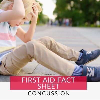 Boy clutching his head on the floor with potential concussion