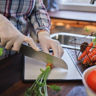 Person cutting carrot with gloves on for flexible food safety training