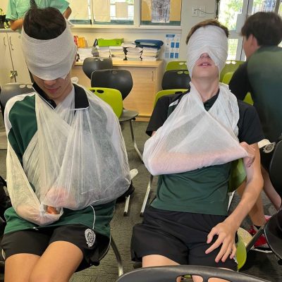 school students having some fun with slings and bandages