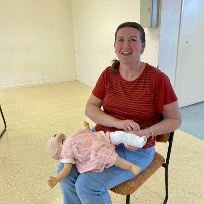 lady with a baby cpr manikin at a Parenting first aid awareness course