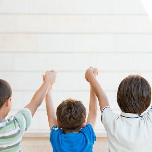 children with their arms up and backs to the camera learning junior safety and and wellbeing