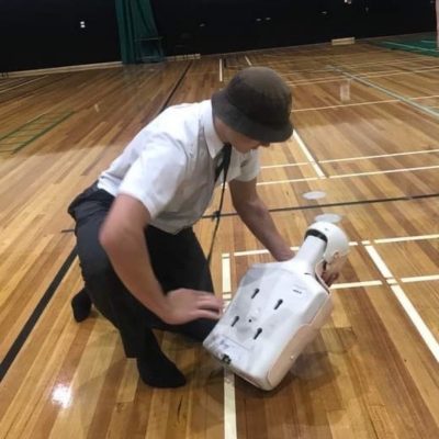 school student practicing first aid management for choking on a manikin in a First Aid Course. First Aid and Mental Health Training for School Teachers