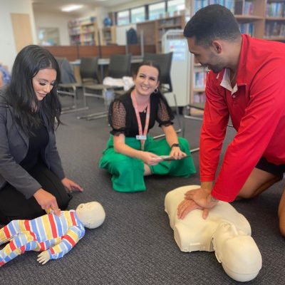 Staff doing CPR training on a manikin, staff first aid training schools Queensland