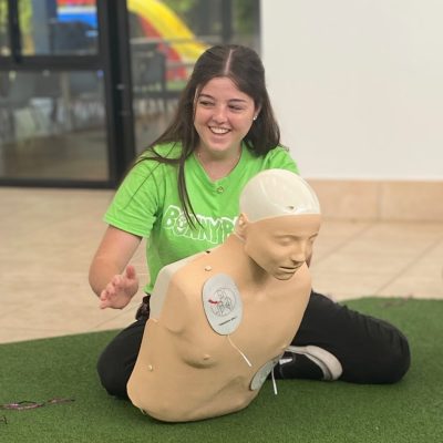 childcare educator practicing choking first aid on a manikin f in a staff first aid and cpr class on the Gold Coast