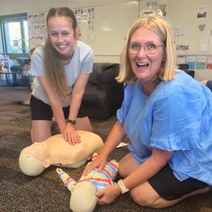 2 staff having fun doing HLTAID009 Provide Cardiopulmonary Resuscitation at staff training ffor their workplace