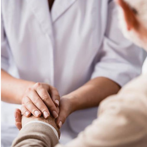 Woman holding hands with elderly learning to communicate in complex situations in the health care industry