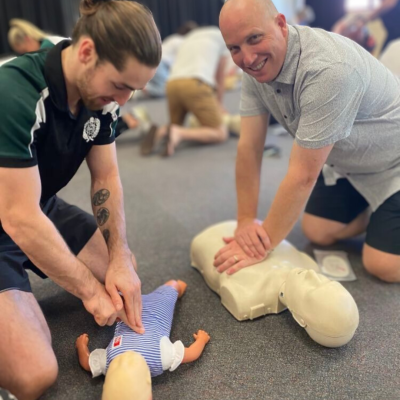 2 men doing cpr on manikins at workplace first aid and cpr training, workplace first aid training Brisbane