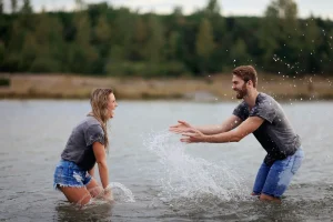 lady and man playing in water. Identifying the importance of men taking care of their health. Men's mental health is a priority.