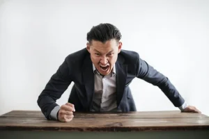 Angry man hitting a table