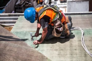 Man hammering a nail into a board 