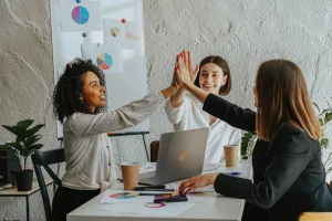 Women working together doing high fives
